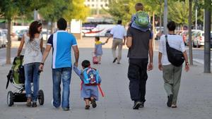 Unos padres llevan a sus niños al colegio.