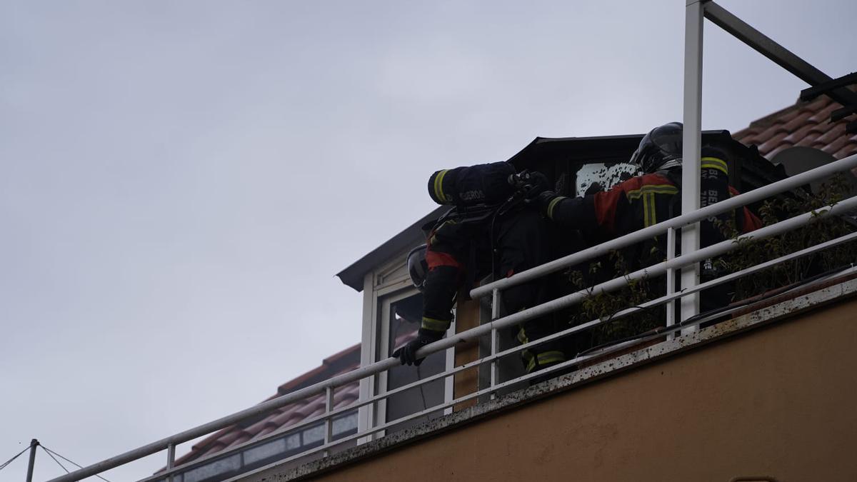 Dos bomberos, en la caseta del ático de la calle Almaraz.