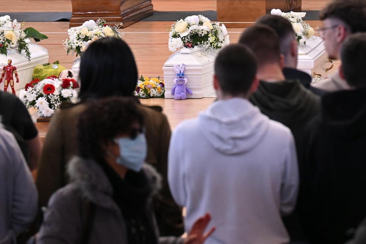 Familiares junto a los ataúdes de las 65 víctimas de un devastador naufragio de inmigrantes frente a la costa sur de Italia