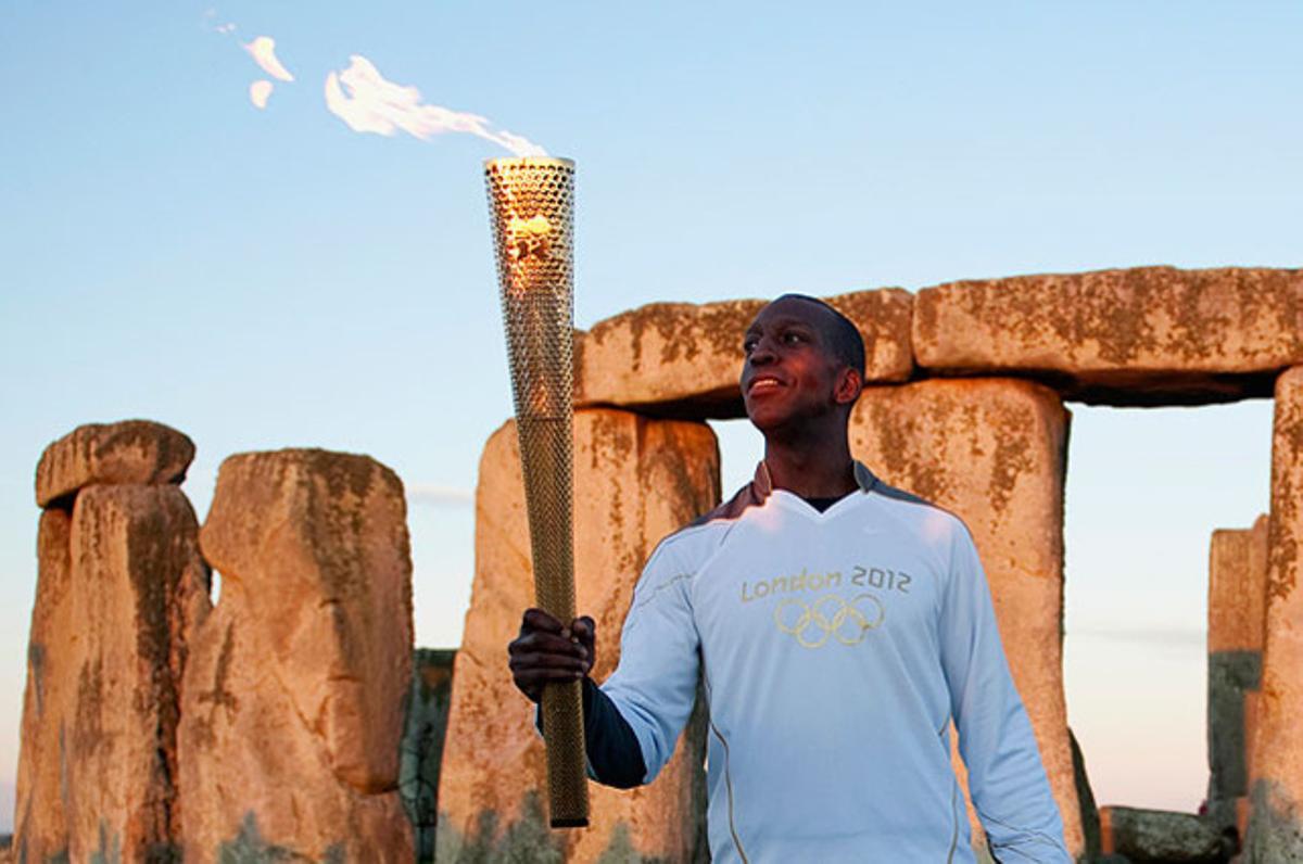 L’exatleta olímpic dels EUA Michael Johnson sosté la torxa olímpica davant el monument de Stonehenge, a Salisbury (Anglaterra).
