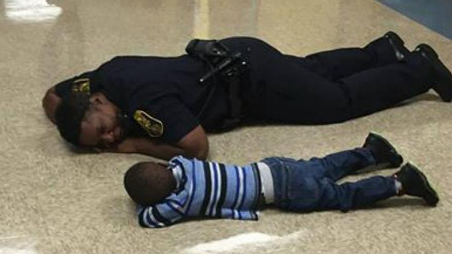 Conmovedora imagen de una policía que se tira al suelo para consolar a un niño