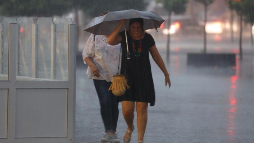 Una joven se guarece de la última tormenta bajo un paraguas.