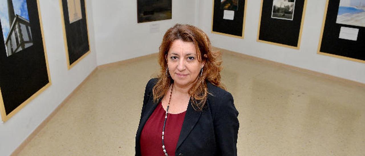 La directora del IES Faro, Paqui Sosa, ayer junto a la serie de lienzos de Hernández que versan sobre el monumento emblemático del Sur.
