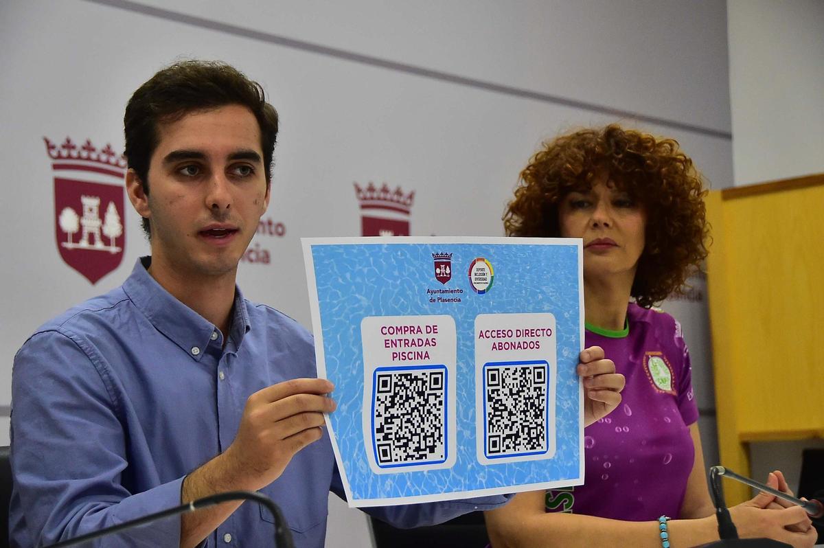 El concejal muestra el QR para acceder a la compra de entradas a la piscina de Plasencia.