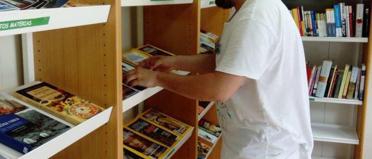 Alejandro Capín coloca unas revistas en el interior de la caseta.