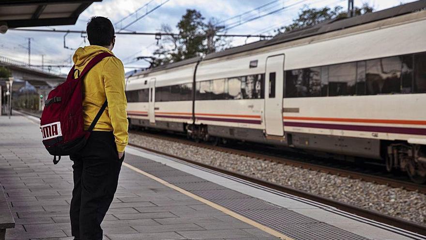 Un jove esperant el tren a l&#039;estació de Maçanet-Massanes.