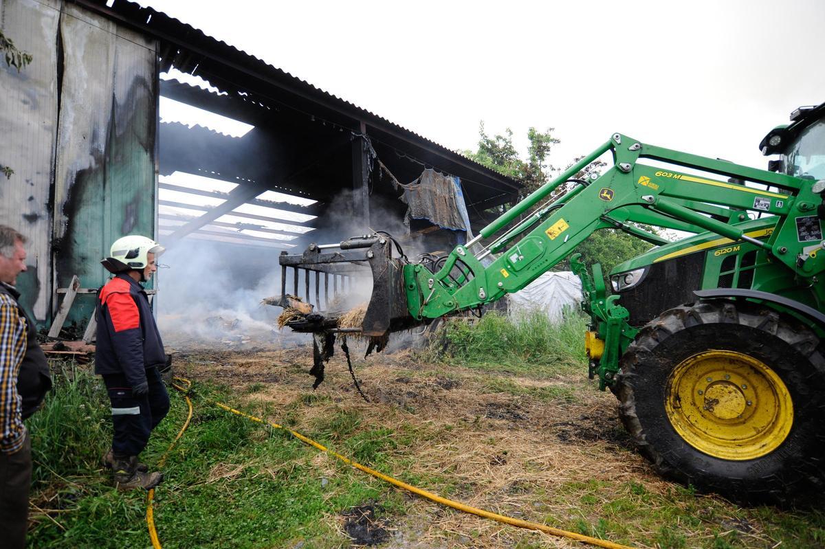 Retirada de material inflamable, ayer, durante el incendio del alpendre de Saídres.