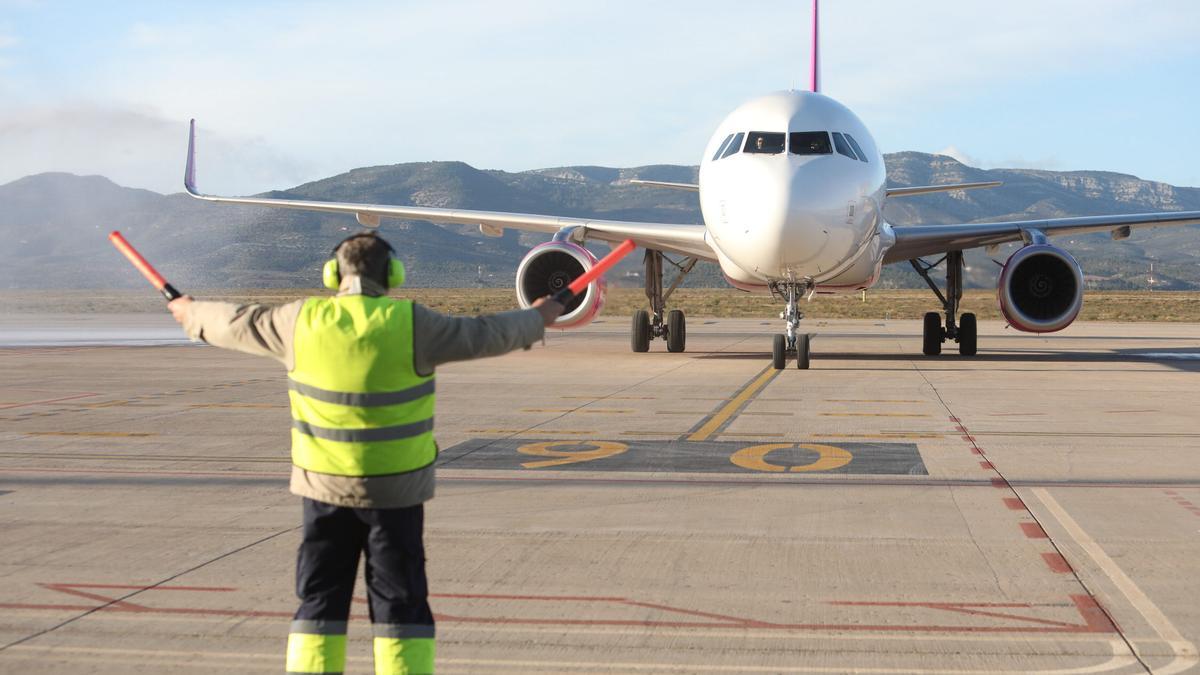 Un operario realiza indicaciones para el despegue de un avión en Vilanova d'Alcolea.