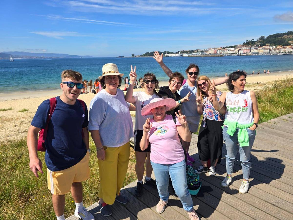 Docentes del IES A Guía de Vigo con sus alumnos, detrás, disfrutando en la playa de Rodeira de la excursión de fin de curso.