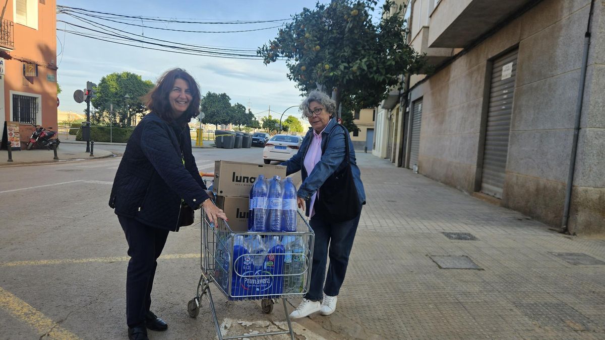 La alcaldesa pedánea lleva un carro de agua al centro de recogida