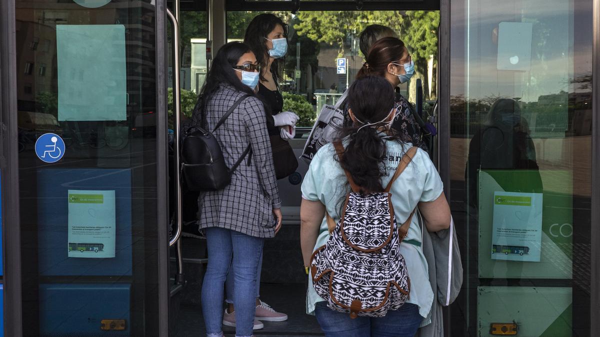 Jóvenes suben a un autobus de la EMT con la mascarilla puesta