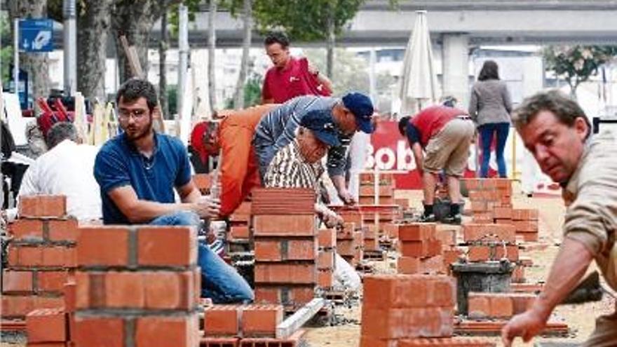 Els participants al 17è Concurs de Paletes, fent les seves construccions a la plaça Poeta Marquina.