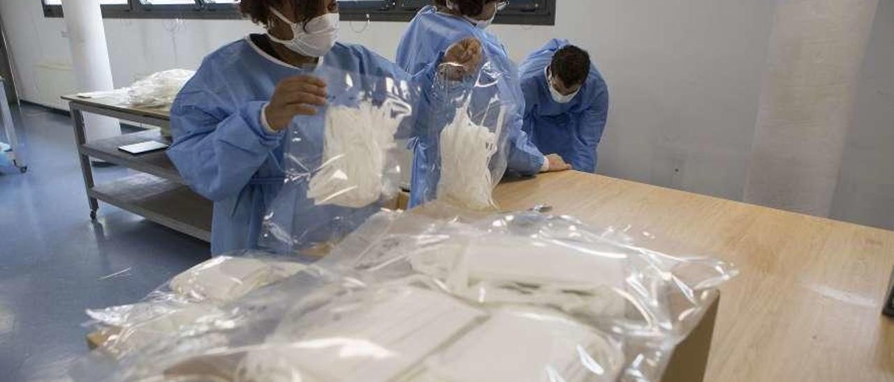 Trabajadores del Centro de Formación Ocupacional de La Corredoria envasando mascarillas.