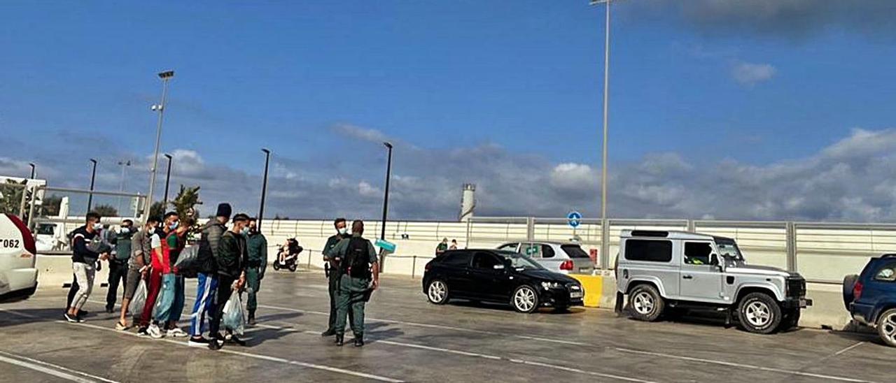 Parte de los migrantes esperan en la Savina, pasado el mediodía, para embarcar hacia Ibiza.