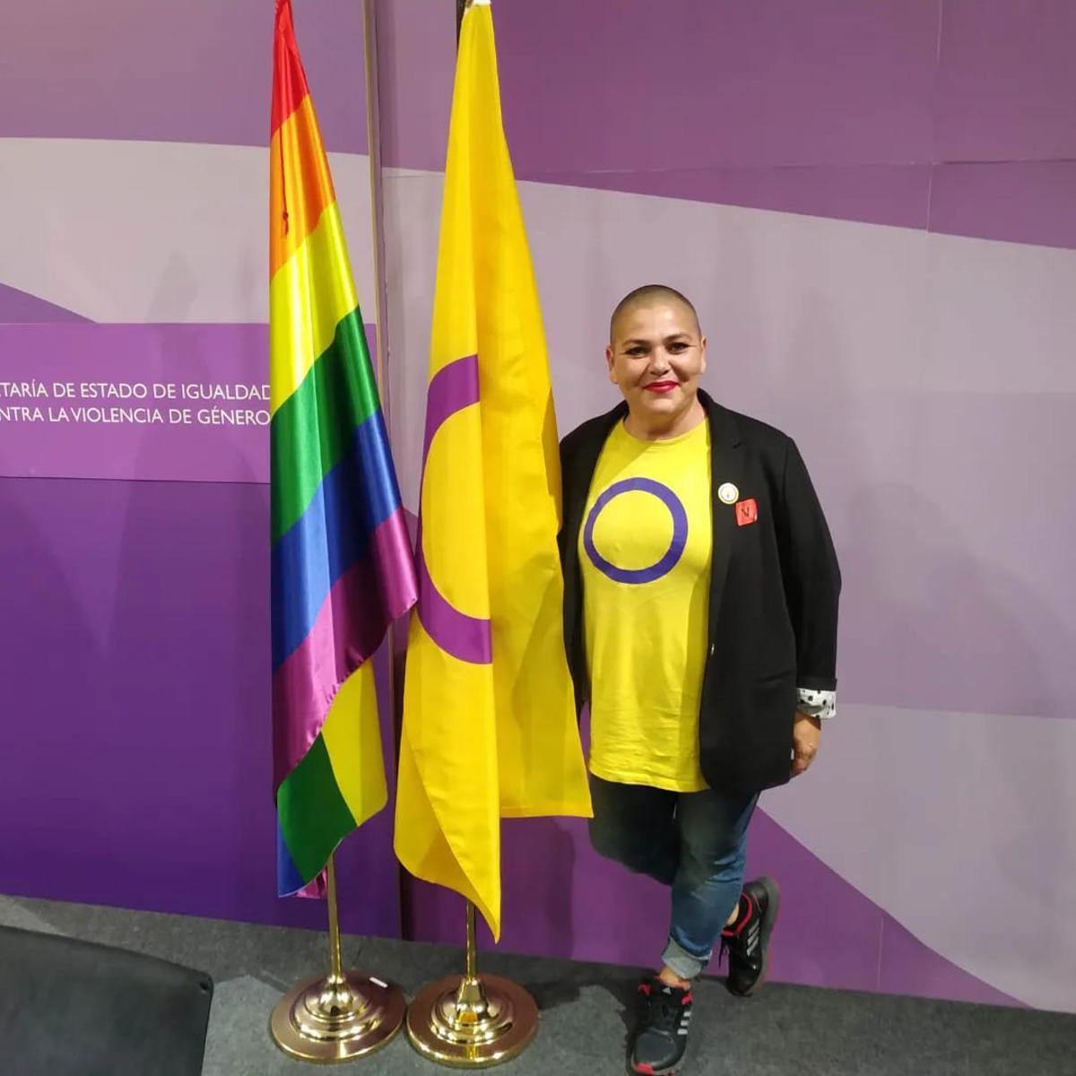 Clara Montesdeoca, fundadora de la asociación Camina Intersex, con la bandera Intersex y la bandera LGBTI.