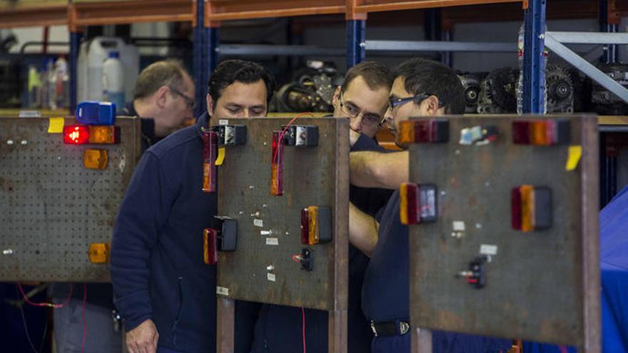 Unos trabajadores en su puesto de trabajo.