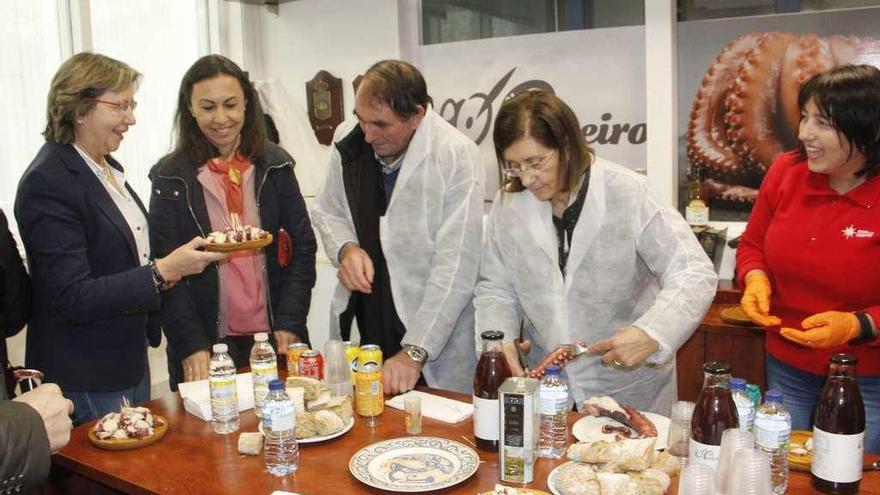 La conselleira, con la alcaldesa, prueban el pulpo envasado por la empresa Rosa de los Vientos. // S.A.