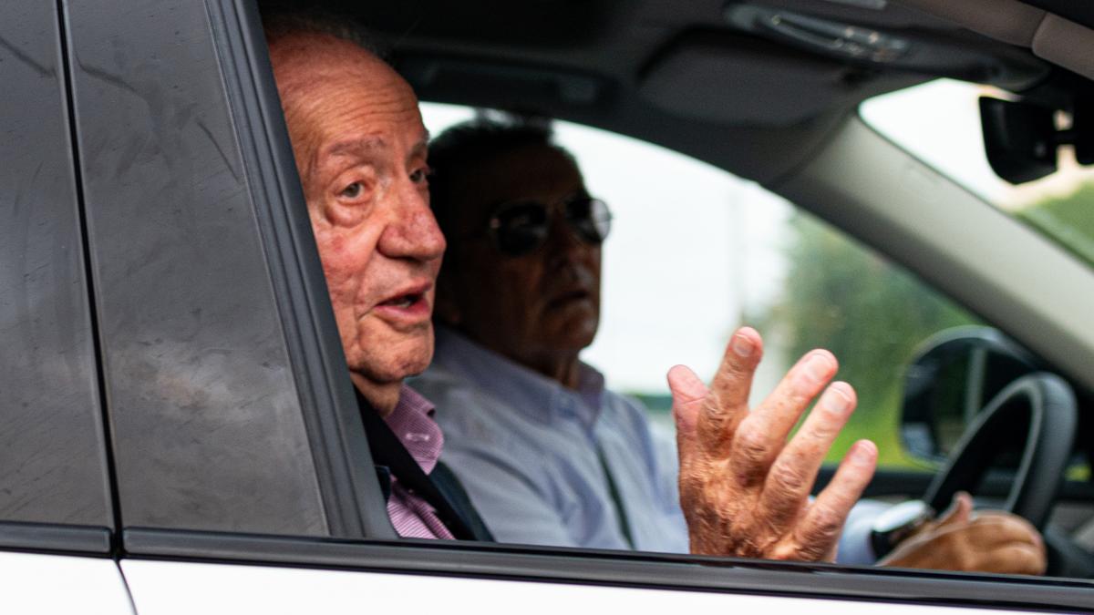 El rey Juan Carlos (i) saluda a su salida en coche de casa de Pedro Campos hacia el aeropuerto de Vigo.