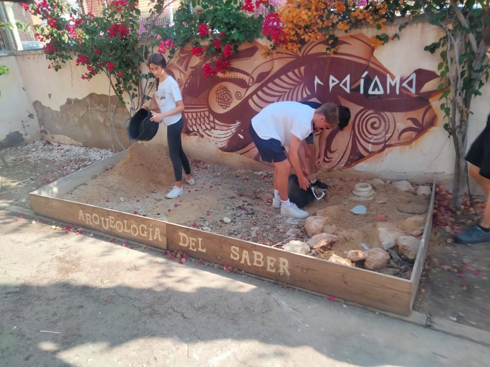 Unos alumnos en el área experimental arqueológica instalada en el patio del IES La Asunción de Elche.