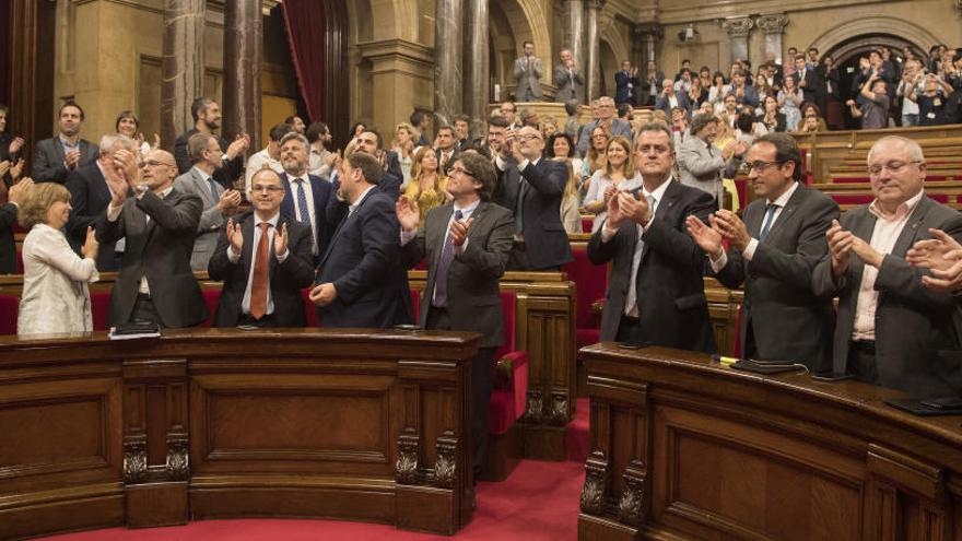 Los diputados aplauden tras aprobar la ley.