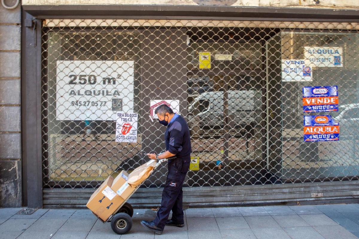 Un repartidor ante un comercio cerrado en una imagen de archivo. EFE/David Aguilar