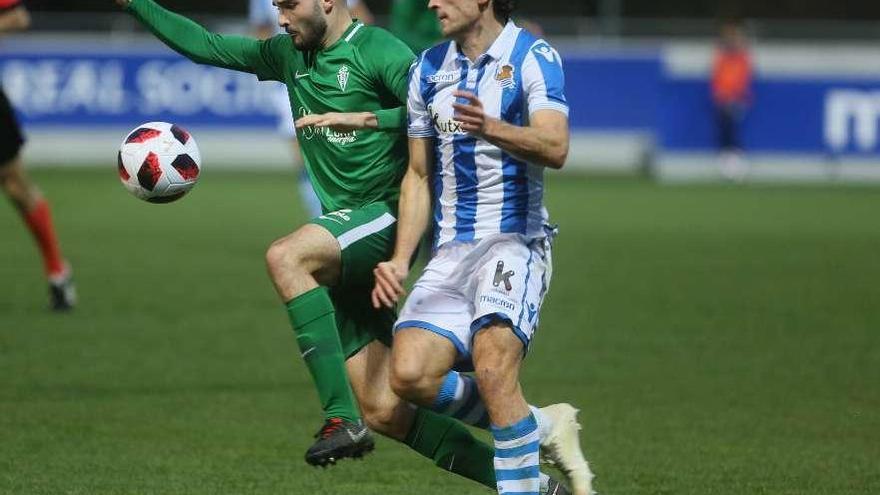 El jugador del Sporting B Aizpiri trata de marcharse de un jugador de la Real Sociedad B.