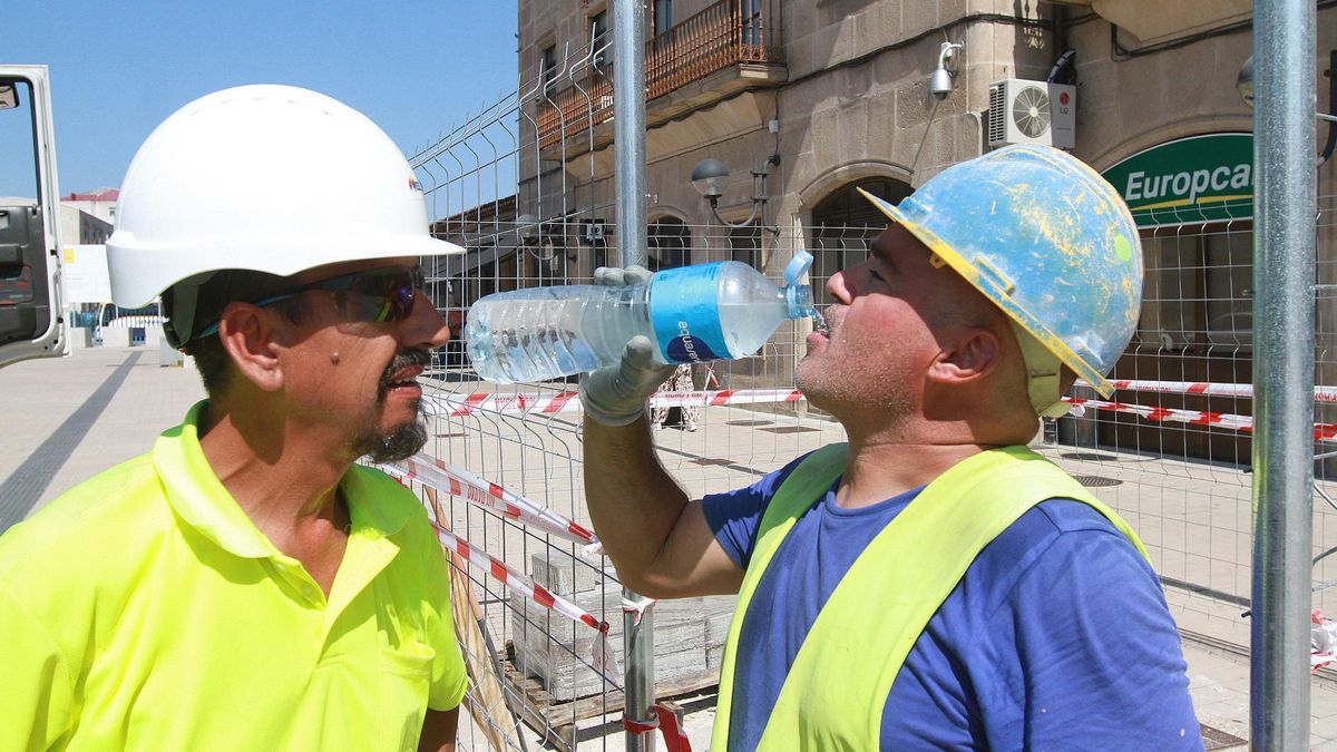 Dos operarios se refrescan bebiendo agua fría.