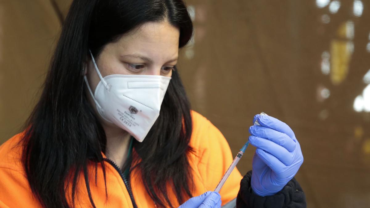 Una sanitaria prepara una vacuna contra el COVID-19 en León.