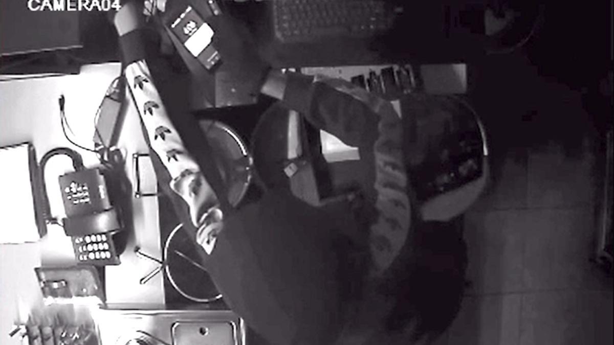 El ladrón, manipulando la caja, en imágenes captada por la cámara de seguridad.