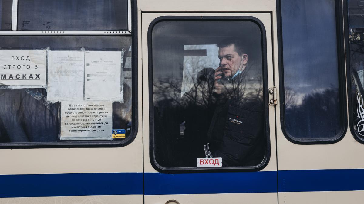 Un hombre mira desde un autobús que lleva a desplazados del Donbass hacia el oeste del país