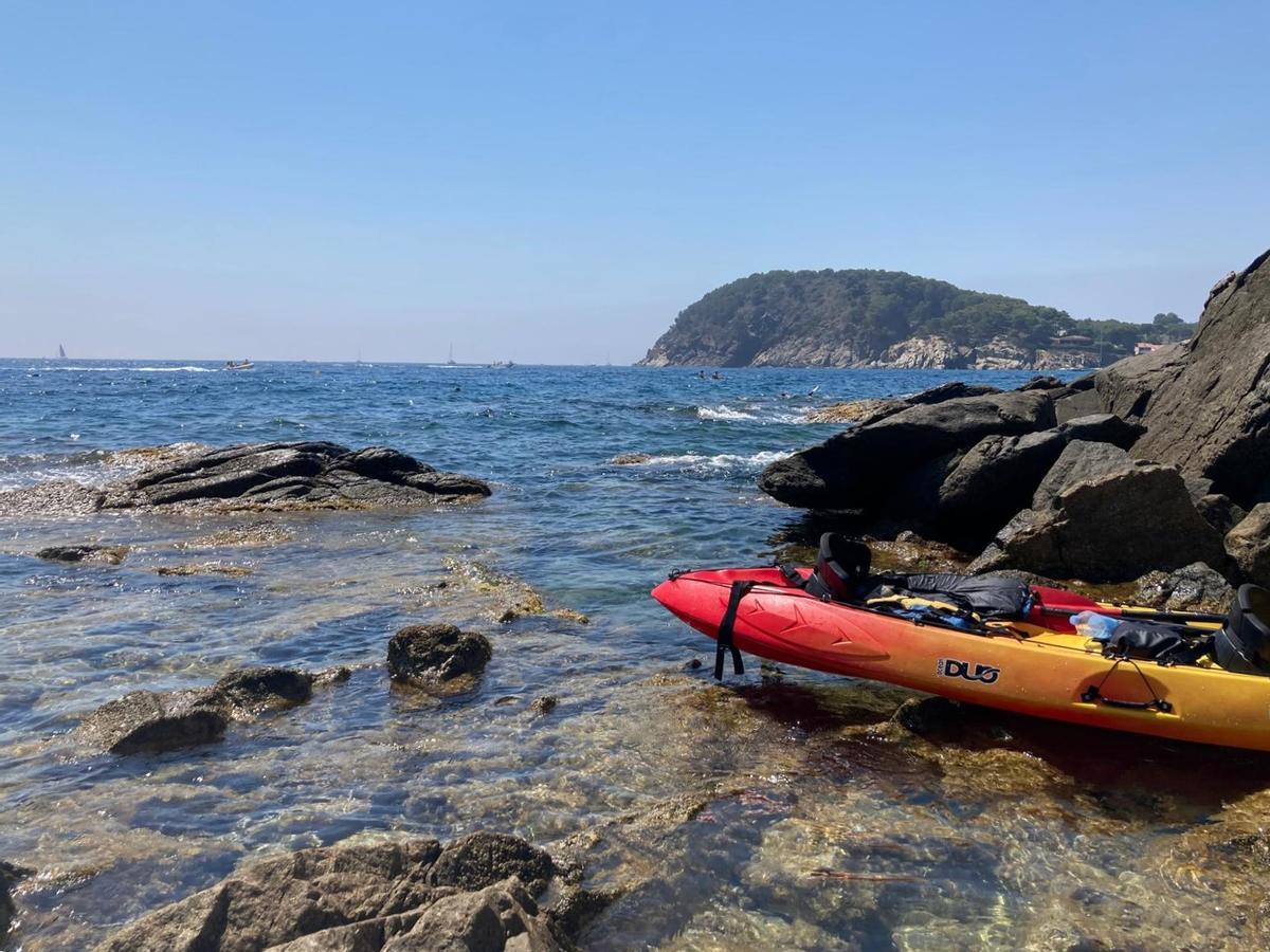 Un kayak descansando sobre la costa rocosa del norte de Palamós.