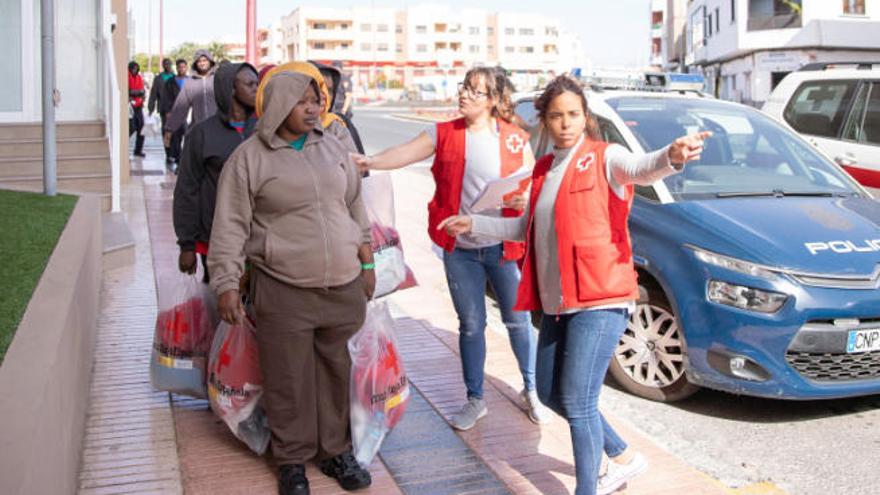 Personal de Cruz Roja distribuye a los migrantes en los vehículos para el traslado al aeropuerto insular, ayer.