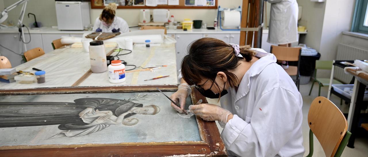 Alumnas de la Escola Superior de Conservación e Restauración de Bens Culturais de Galicia, ayer, trabajando con diferentes piezas en el taller.