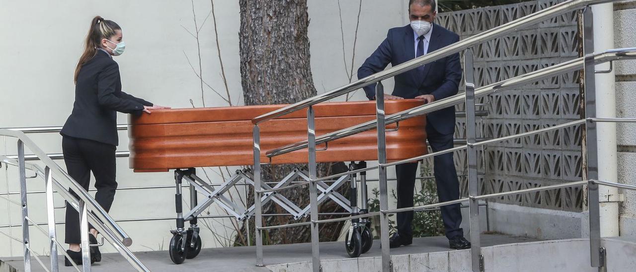 Dos operarios de funeraria trasladan a un fallecido, en una imagen de archivo. | FRANCISCO CALABUIG