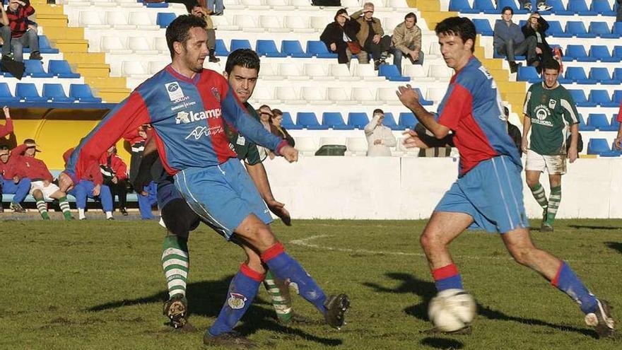 Miguel realiza un pase con Lekumberri a la derecha en un duelo del Langreo ante el Llanes jugado en El Florán.