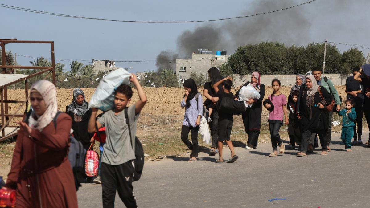 Familias palestinas que huyen de la ciudad de Gaza y otras partes del norte de Gaza hacia las zonas del sur, caminan por una carretera en medio de las batallas en curso entre Israel y el movimiento palestino Hamas.