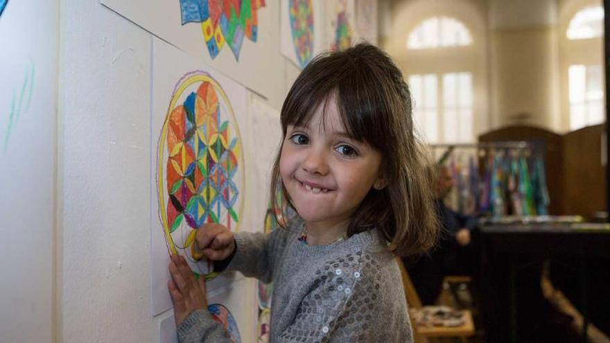 Sabina Cartas, ayer, pintando su mandala en la plaza de Trascorrales. A la derecha, Inés Pedreira y Marta Silva, coloreando.