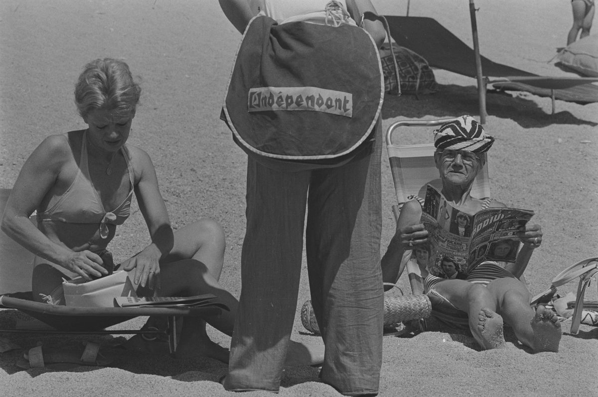 Venedor ambulant de 'L’Indépendant' en plena platja. Platja d’Aro, juliol de 1974.