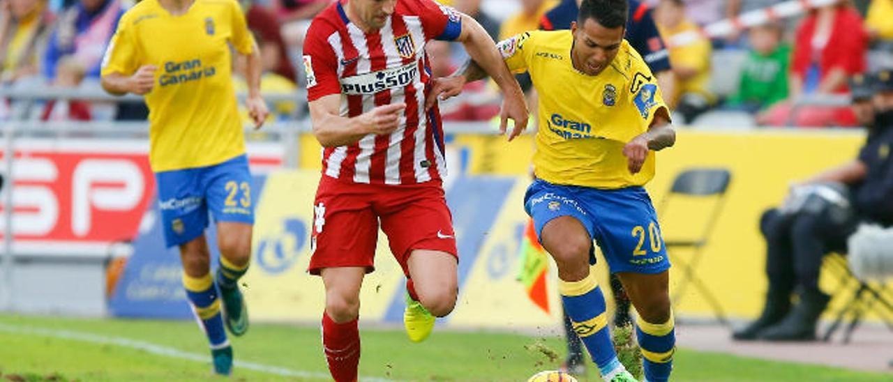 El mediapunta de la UD Jonathan Viera controla el esférico con el marcaje del capitán del Atlético, Gabi.