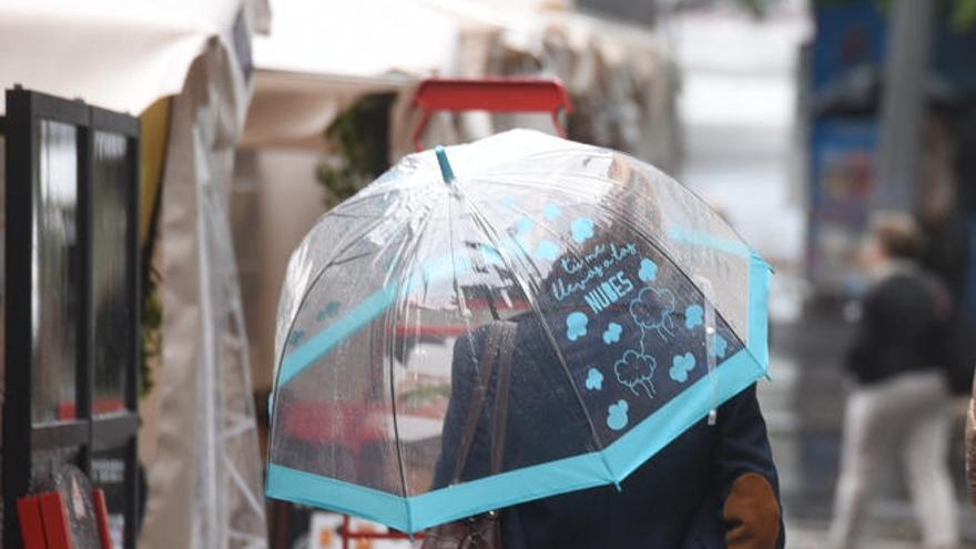 Una mujer se protege de la lluvia.