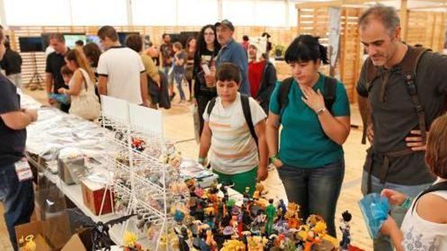 Un grup de visitants observa un dels expositors del saló del còmic gironí.