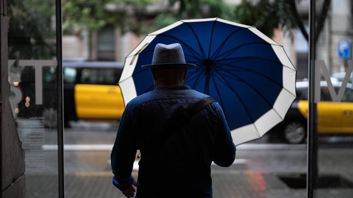 Un hombre con un paraguas bajo la lluvia.