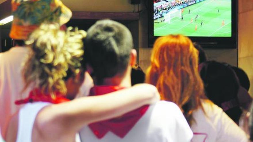 Un grupo de aficionados, viendo un partido de fútbol en un bar.