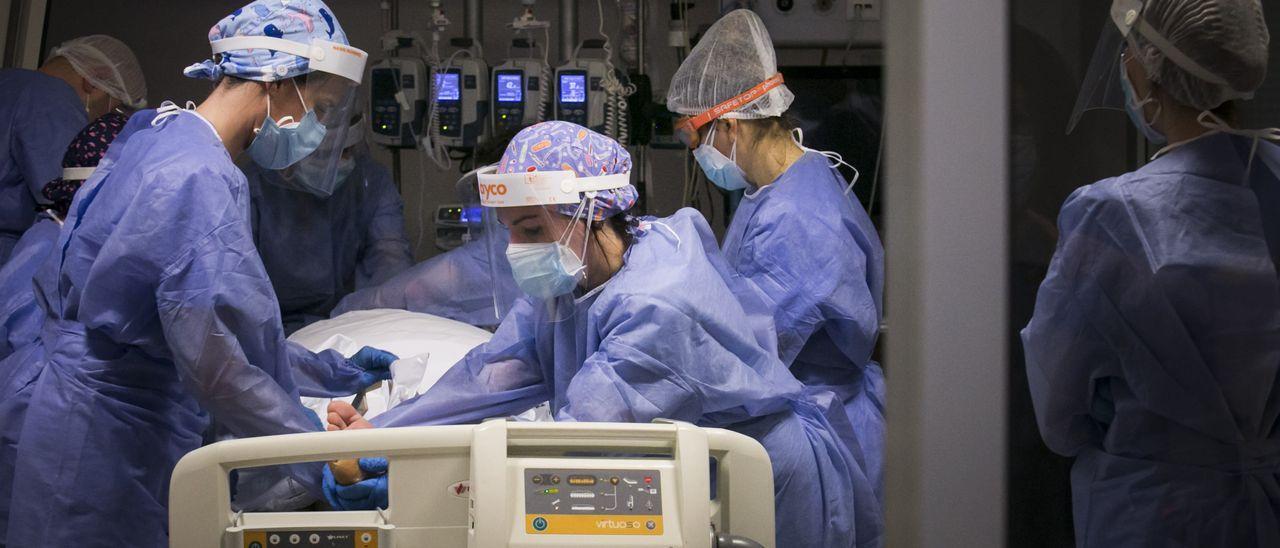 Sanitarios atienden a un paciente covid en la UCI del HUCA. | Irma Collín