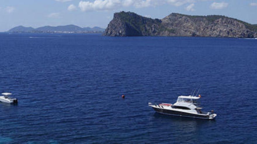 Embaraciones fondeadas en la costa ibicenca con Tagomago al fondo.