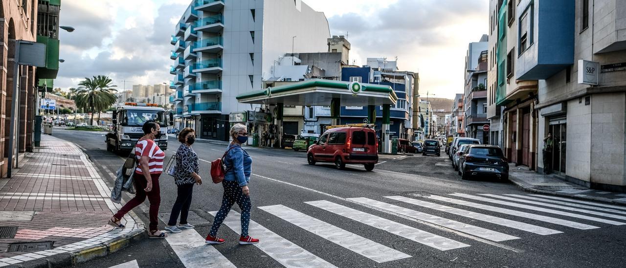 Tres mujeres cruzan por un paso de peatones.