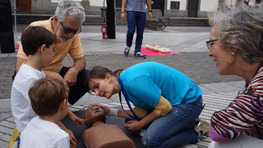 El exrector de la ULPGC José Regidor y sus nietos en el taller de Reanimación Cardiopulmonar en la Plaza de Colón.