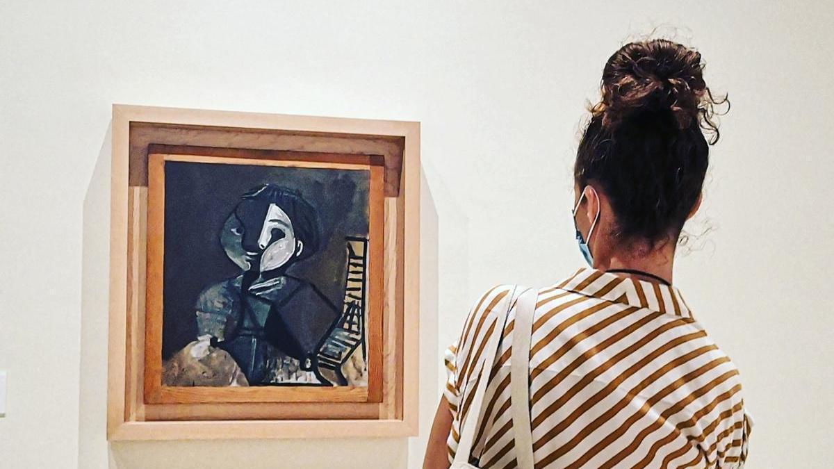 Una visitante contempla la obra 'Claude en marrón y blanco' (Vallauris, 1960), en las salas del Museo Picasso Málaga