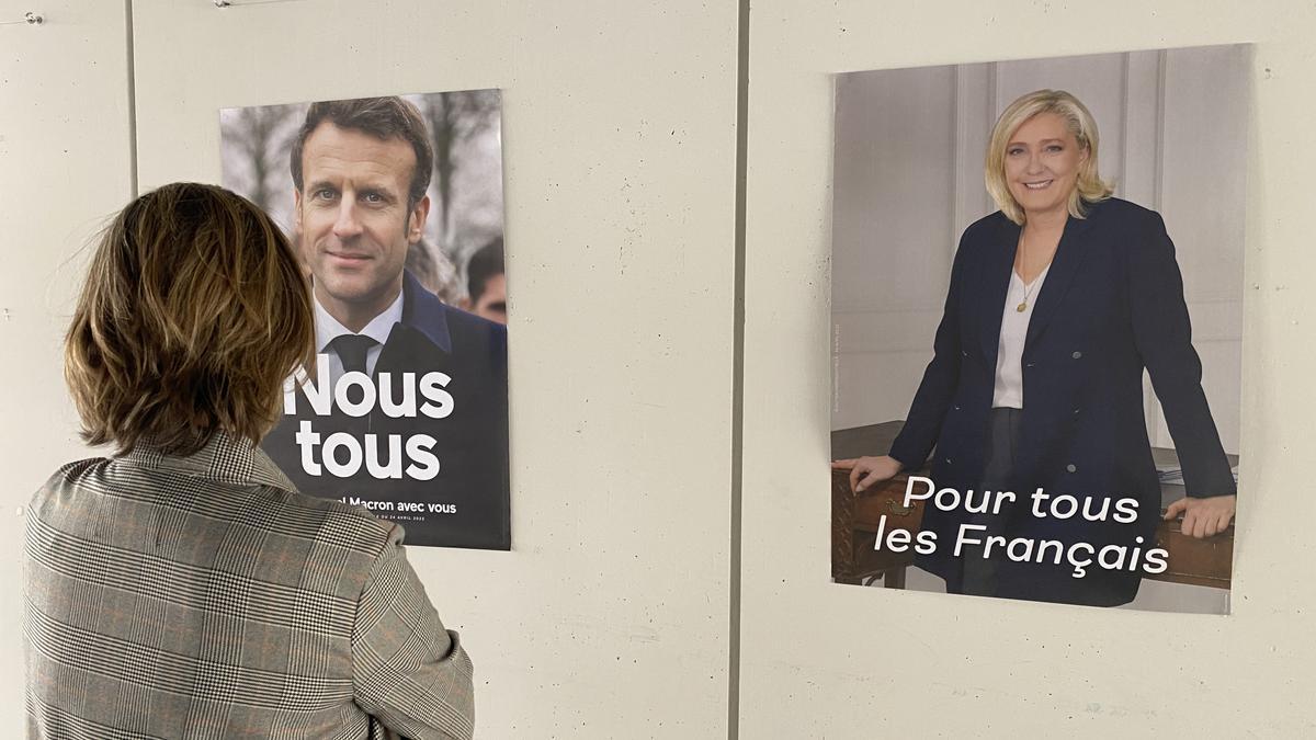 Una ciudadana observa los dos carteles electorales colgados en el vestíbulo del Liceó Frances