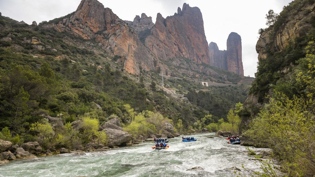 A la izquierda, varios grupos descienden por el RÍO Gállego, a su paso por los Mallos de Riglos.